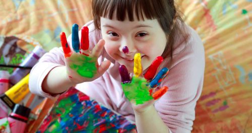 Enfant avec de la peinture sur les mains. Enfants atteints d'une affection.