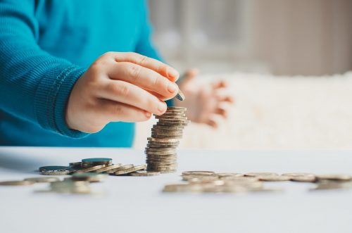 Un enfant empile des pièces de monnaie. Montants payés. 